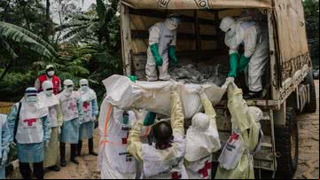Funcionários da saúde transportando vítima de doença desconhecida no Congo - Getty Images