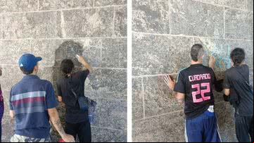 Jovens que picharam muro fazendo a limpeza - Divulgação/Segurança Presente
